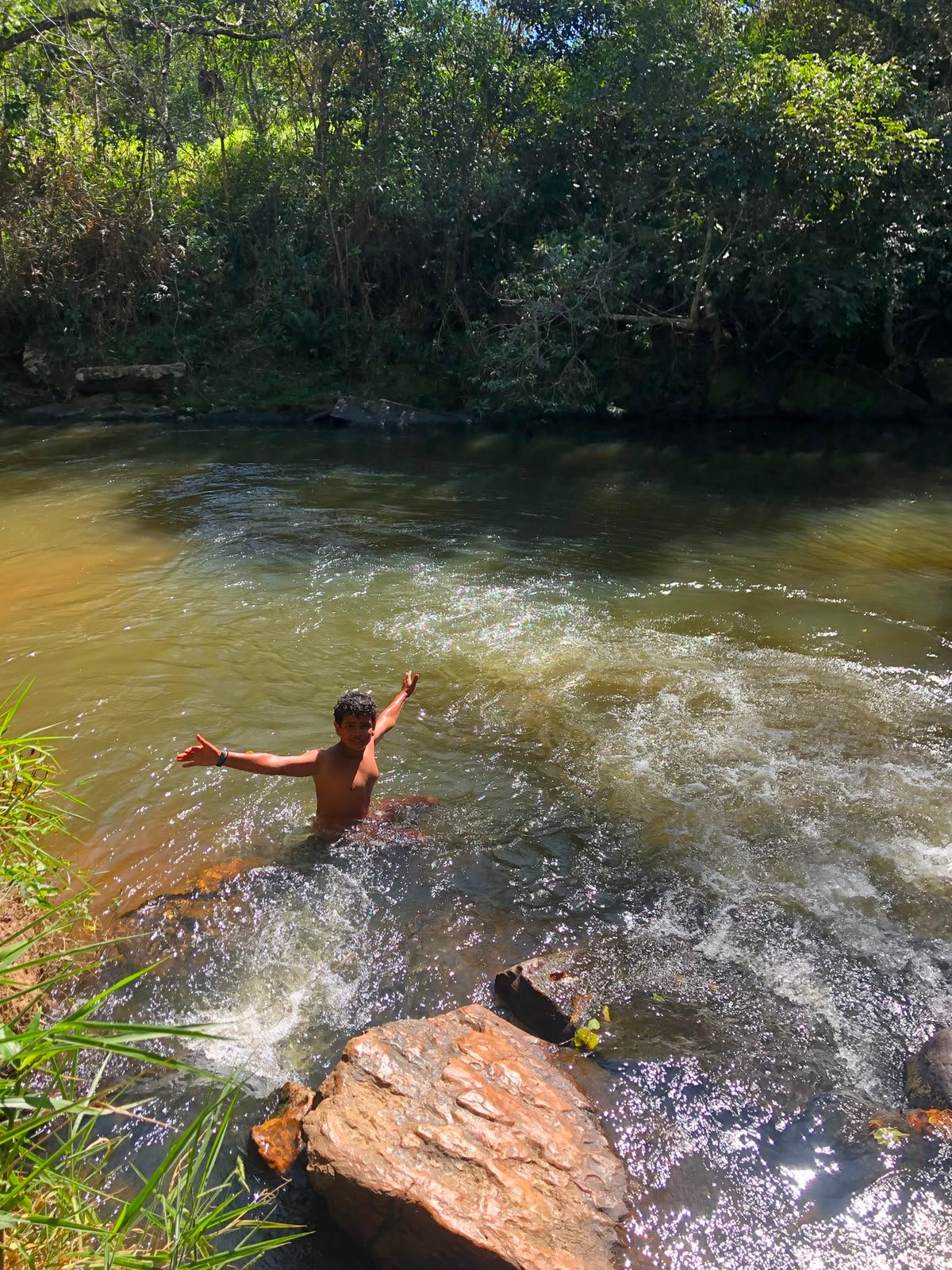 Participante brincando no rio durante a expedição