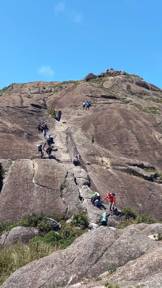 Grupo subindo a face de rocha em direção ao cume do Pico do Marins